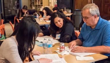 People sitting around table learning at JANM education workshop